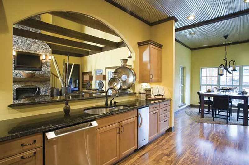 Eat-in kitchen with a granite countertop, wooden cabinets, and a double bowl sink paired with a gooseneck faucet.