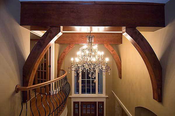 A closer look at the ornate chandelier hanging from the beamed ceiling.