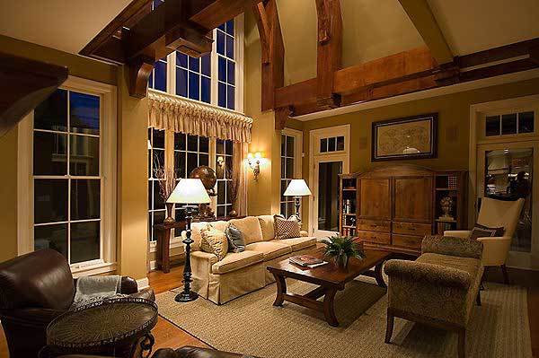 Beige skirted sofa, upholstered high back chair, Cleopatra bench, and a wooden coffee table complete the living room.