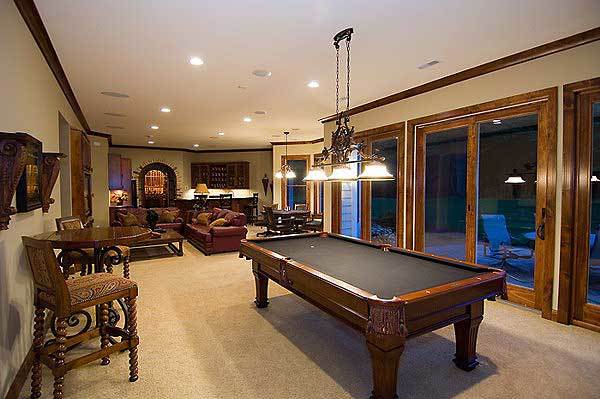 Recreation room with multiple seating and a billiard table illuminated by glass dome pendants.