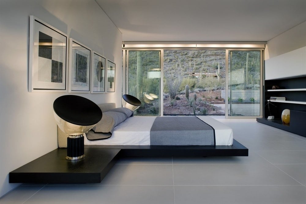 This bedroom has a modern floating platform bed flanked with modern black table lamps that stand out against the white walls. Image courtesy of Toptenrealestatedeals.com.