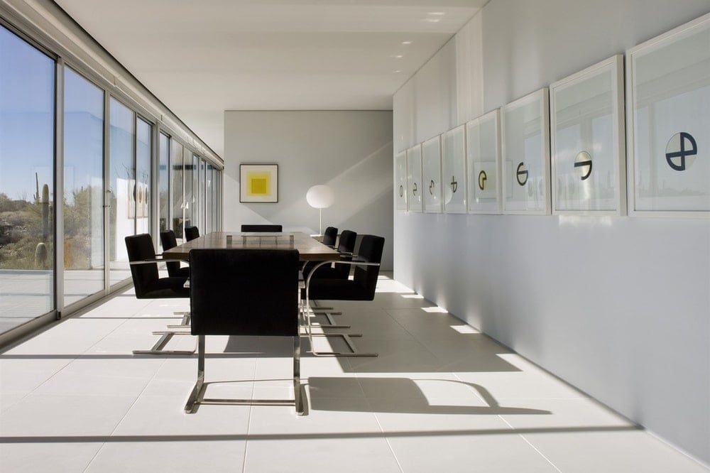 This is a closer look at the dining area a few steps from the living room area. It has a dark dining table surrounded by black chairs to contrast the brightness. Image courtesy of Toptenrealestatedeals.com.