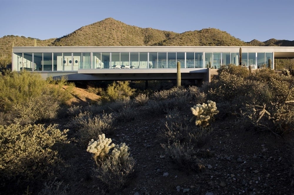 This is an exterior view of the house showcasing the glass walls that show the bright interiors of the house. Image courtesy of Toptenrealestatedeals.com.