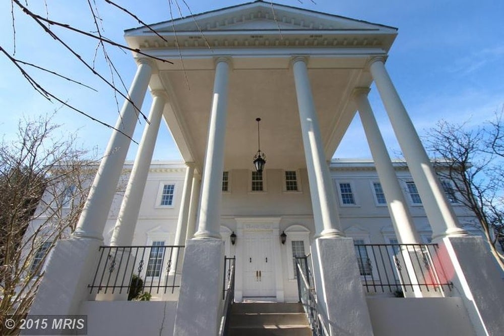 This is a look at the main entrance of the house with a tall white ceiling supported by tall white pillars. Image courtesy of Toptenrealestatedeals.com.