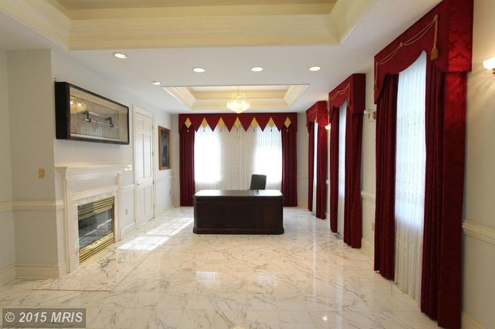 This is the spacious office with a white marble flooring that makes the dark wooden desk stand out. Image courtesy of Toptenrealestatedeals.com.