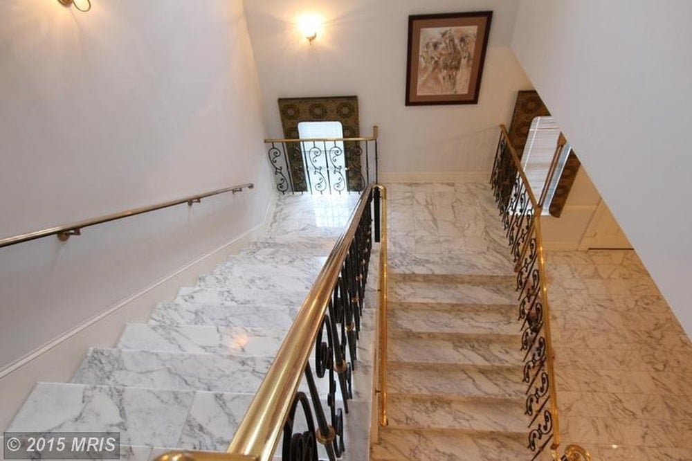 This is a look down the marble steps of the staircase adorned with intricate wrought-iron railings on the side. Image courtesy of Toptenrealestatedeals.com.