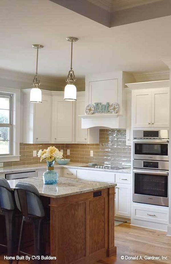A pair of glass pendant lights hanging above the center island illuminates the kitchen.