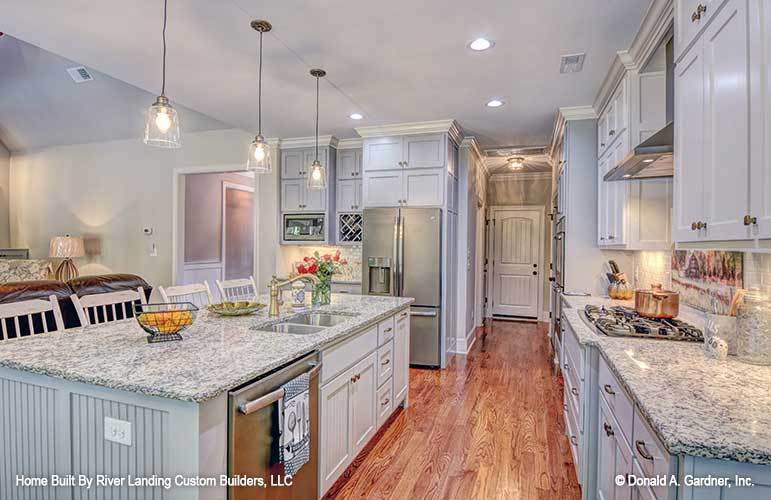 Recessed ceiling lights along with glass pendants that hang over the center island illuminate the kitchen.