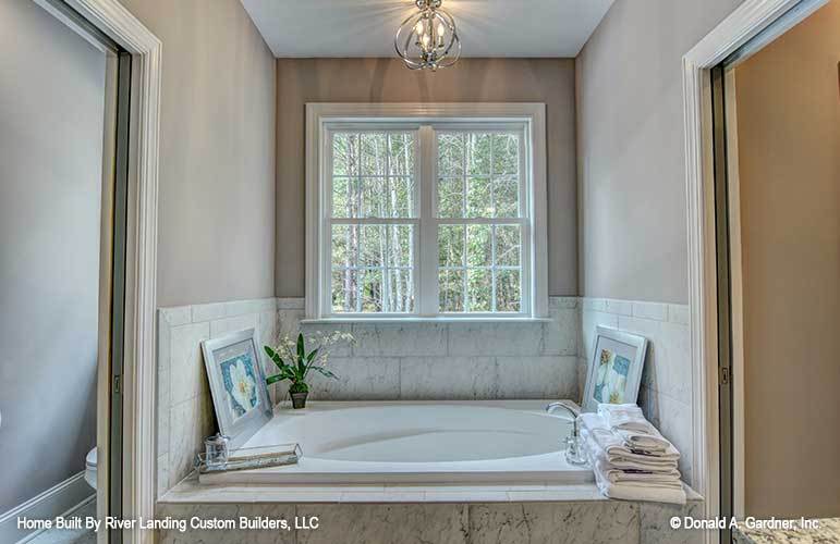 The primary bathroom features a soaking drop-in tub adorned with floral artworks.