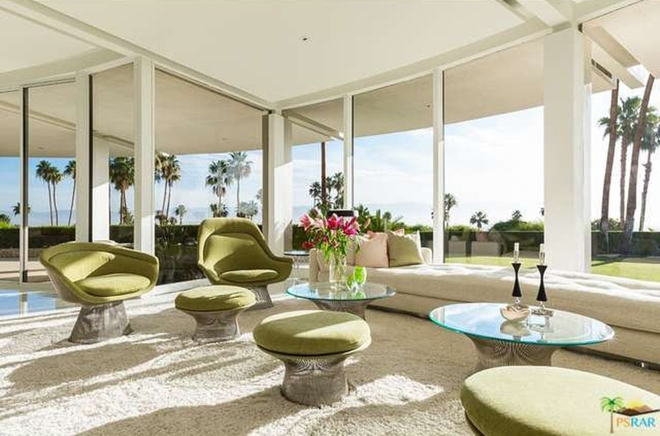 This is a closer look at the living room area just beside the glass wall. The bright beige tones of this area is complemented by the moss green cushions of the ottomans and armchairs. Image courtesy of Toptenrealestatedeals.com.