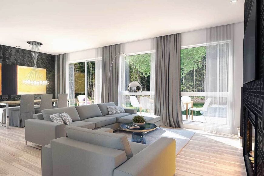 Living room with gray seats, a round coffee table, modern fireplace, and a wall-mounted TV.