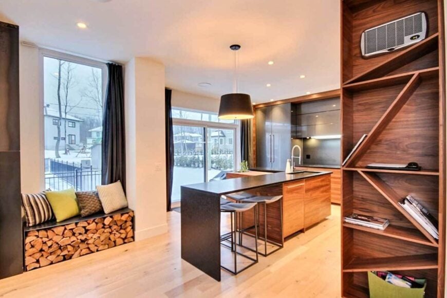 There's a window seat on the side that doubles as firewood storage. It is accented with multi-colored and striped pillows.