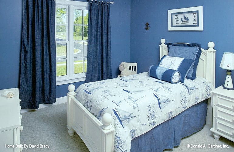 This bedroom showcases white furnishings and blue walls adorned with a white framed artwork.