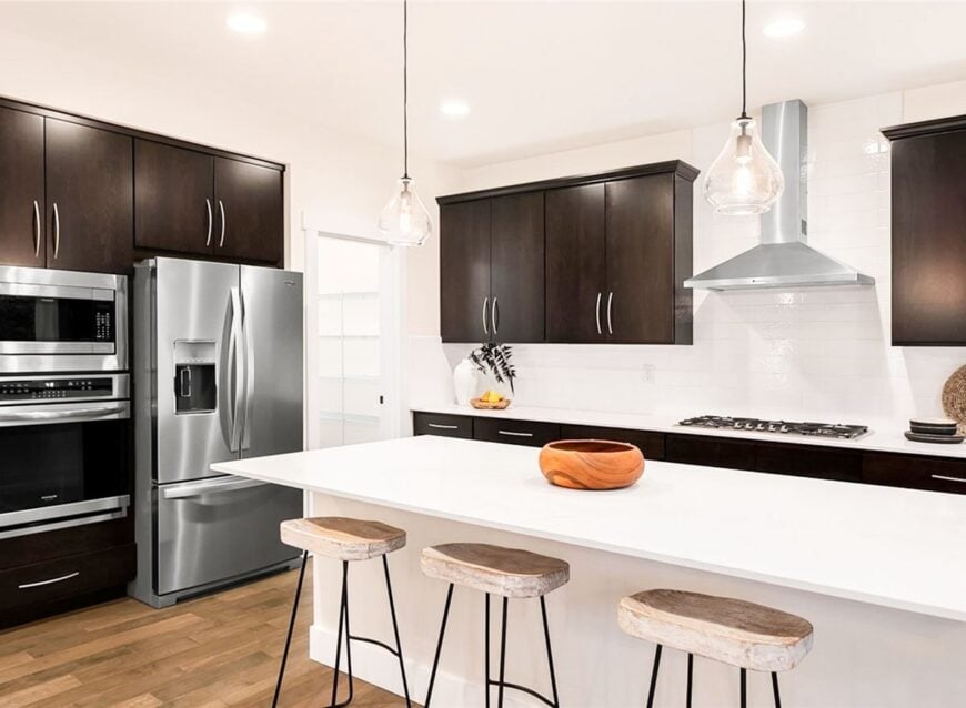 Sitting next to the two-door fridge is the pantry that's filled with white built-in shelves.