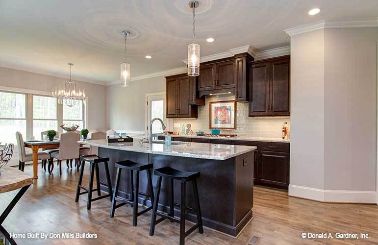 Dark wood bar stools complement the center island that's fitted with an undermount sink.