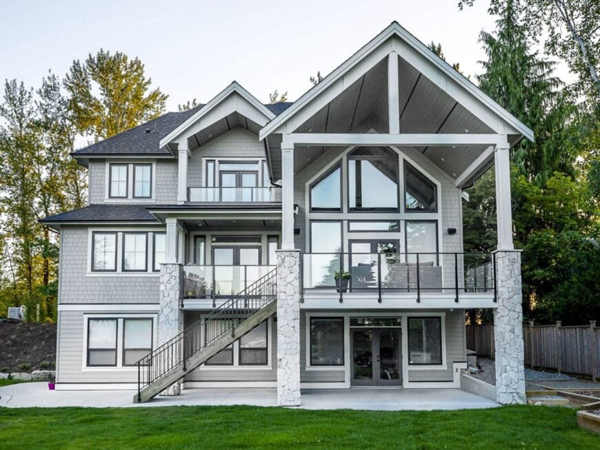 Rear exterior view showing the stone columns and multiple decks enclosed in glass railings.