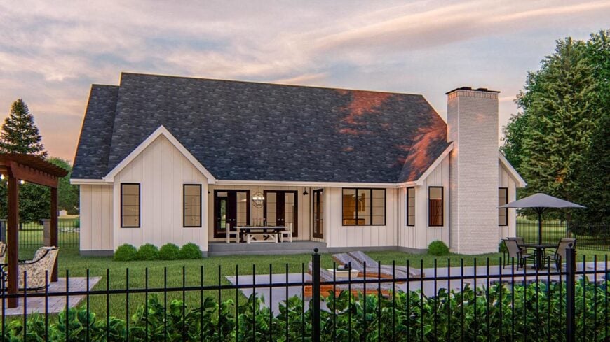 Rear exterior view with brick chimney and a patio filled with outdoor dining.