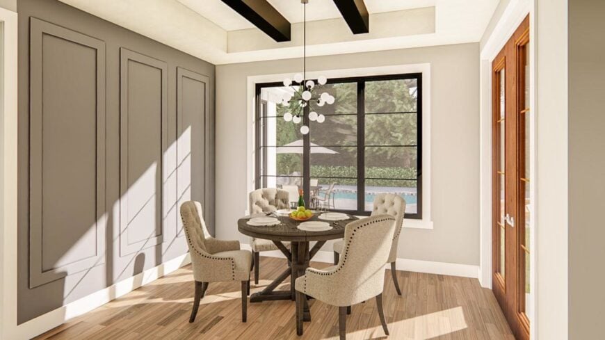 Breakfast nook with a round dining set, gray wainscoted accent wall, and a tray ceiling lined with rustic beams.
