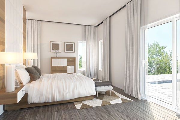 This bedroom offers built-in nightstands and a platform bed with a tufted bench at its end.