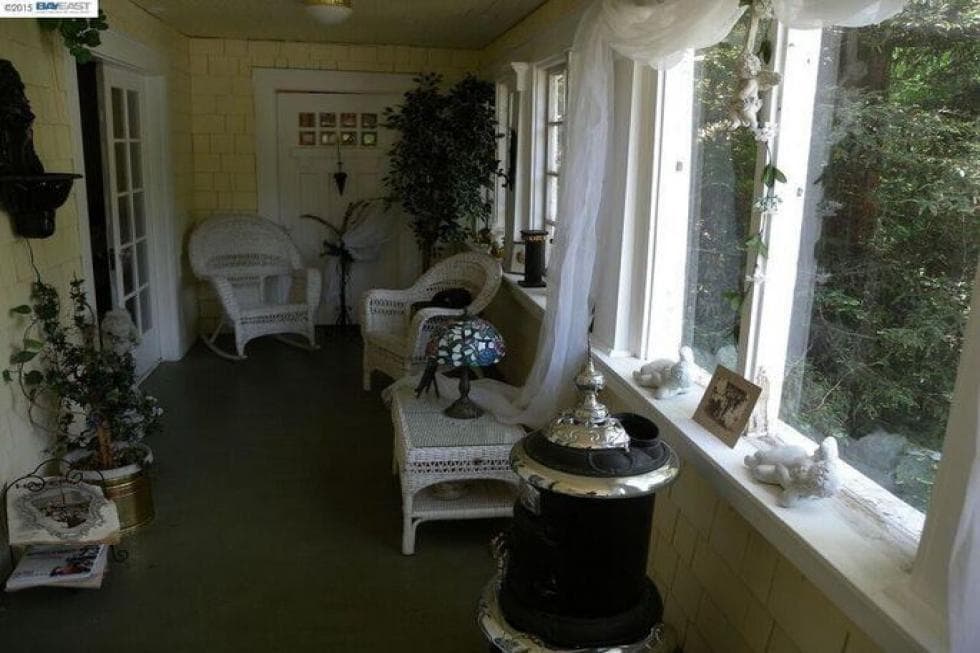 This is the porch that welcomes you upon entry of the house. It has comfortable armchairs and a coffee table. Image courtesy of Toptenrealestatedeals.com.