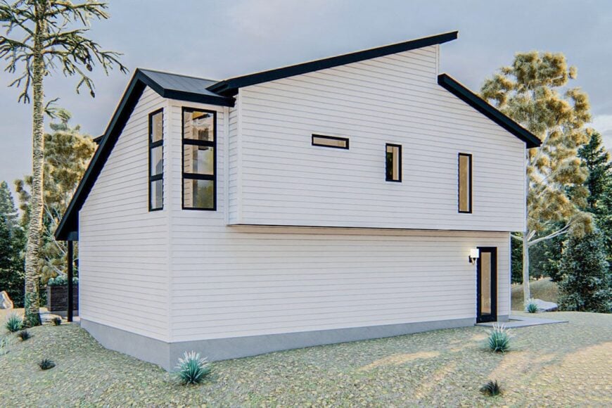 Rear exterior view showing the white horizontal siding, a man door, and slanted rooflines.