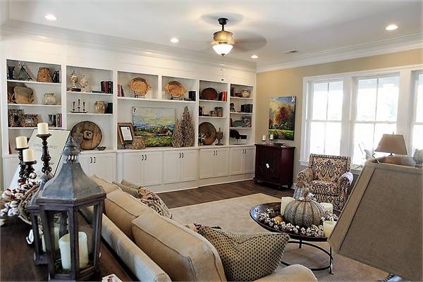 The cozy seats face the large white built-in cabinet filled with various decors.