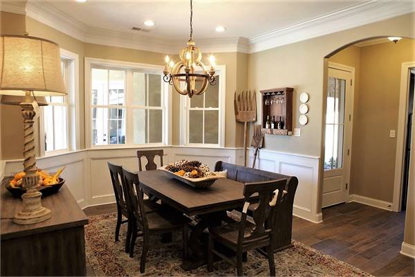 The dining area offers a spherical chandelier, wooden buffet, and a dark wood dining set.