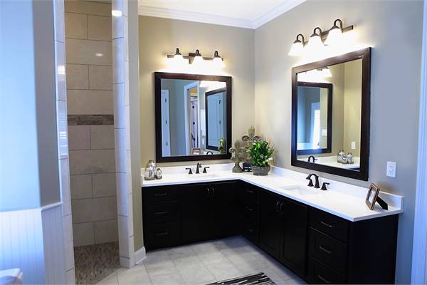 The primary bathroom features a dual sink vanity with black cabinets, marble countertops, and wrought iron fixtures.