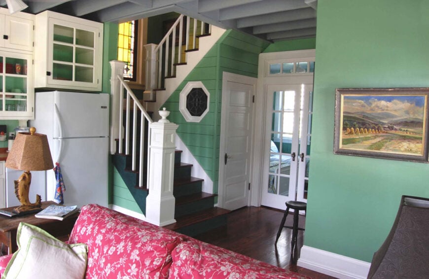 An open layout view showing the living room, kitchen, and a bedroom that rests behind the french door.