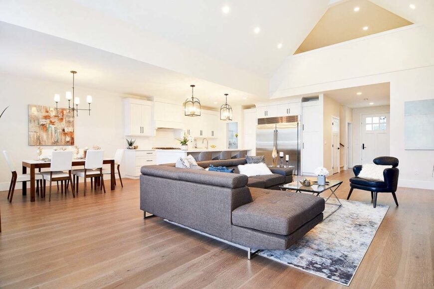 An open layout view showing the living room, kitchen, and dining area adorned with an abstract painting.