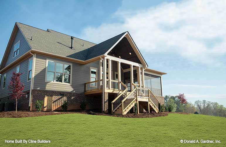 Rear exterior view showing the screened porch and covered deck complemented with bifurcated staircase.