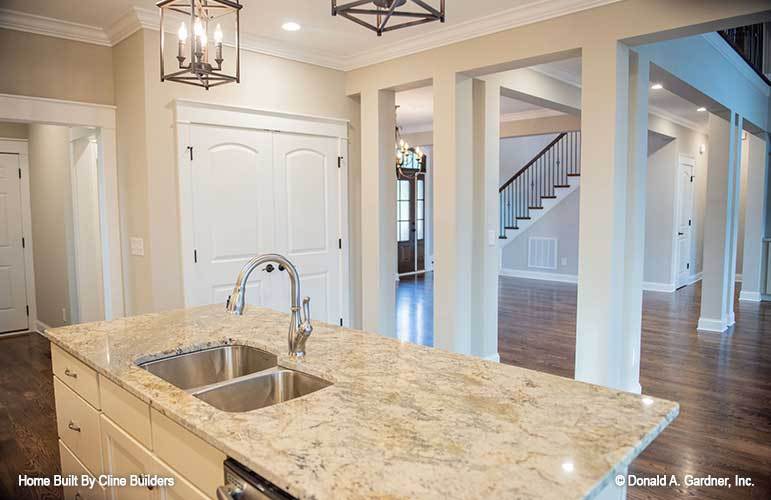 The kitchen island fitted with a double bowl sink overlooks the dining area and living room across.