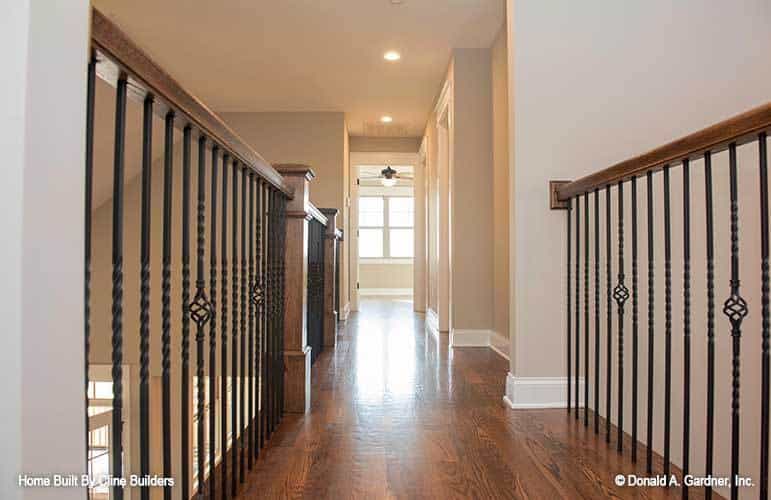 Balcony loft with hardwood floor and ornate wrought iron railings.