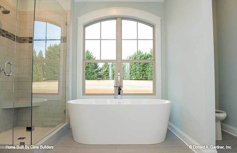 The primary bathroom is equipped with a toilet area, freestanding bathtub, and a walk-in shower.