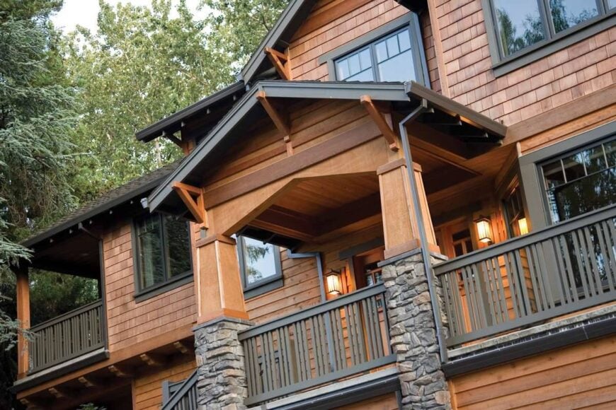 Front exterior view showing the cedar shingles, gable rooflines, and a balcony bordered by metal railings.