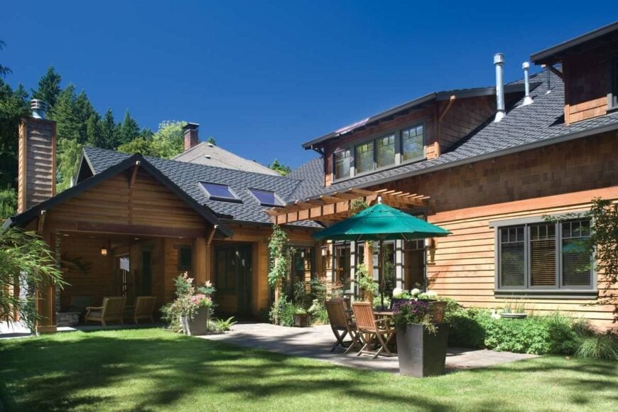Lush green lawn and plants complement well with the covered porch and open patio.