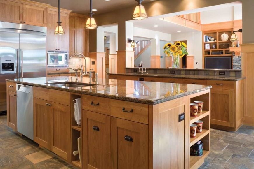 The center island is fitted with an undermount sink, slate dishwasher, and chrome fixtures.