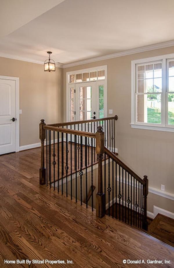 Foyer with a warm glass chandelier and a white entry door fitted with glass panels.