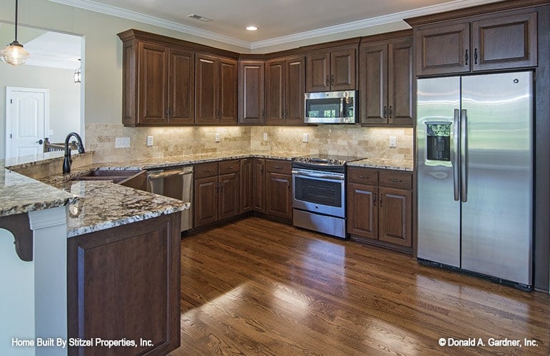 The kitchen offers wooden cabinetry, stainless steel appliances, and granite countertops.