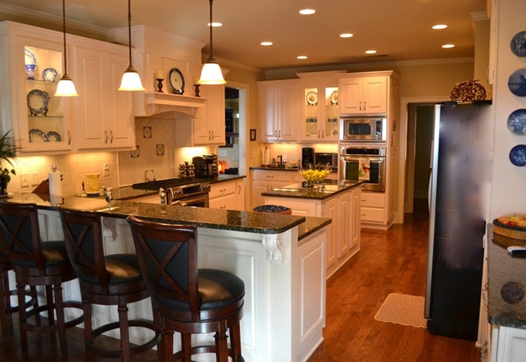 Small glass pendants along with recessed ceiling lights create a cozy ambiance in the kitchen.