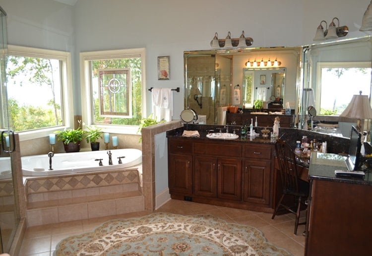 More vanities and a corner bathtub under the picture windows complete the primary bathroom.
