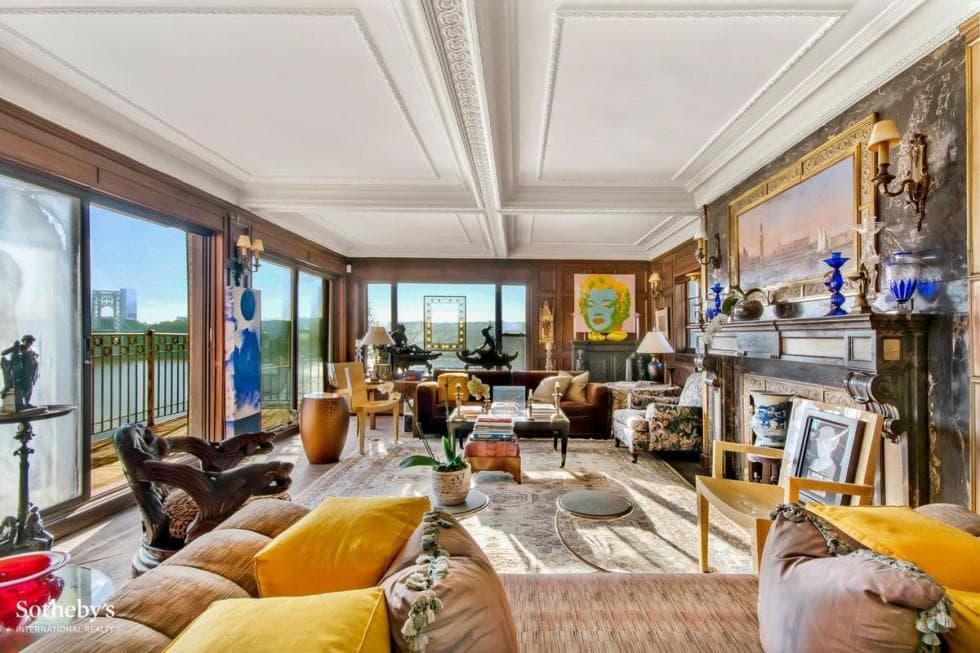 This is the living room of the house with large glass walls that bring in natural lighting. This area has sofas and coffee tables under a white coffered ceiling. Image courtesy of Toptenrealestatedeals.com.