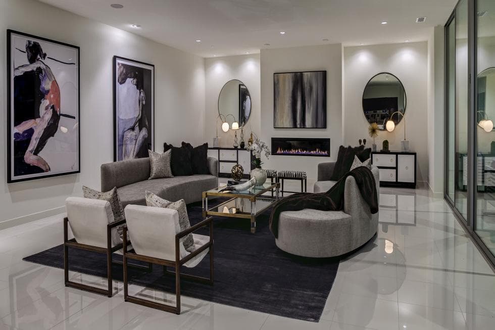 This is the living room that has pure white walls, ceiling and floor. These makes the gray sofa set stand out along with the various wall-mounted artworks and the modern fireplace. Image courtesy of Toptenrealestatedeals.com.