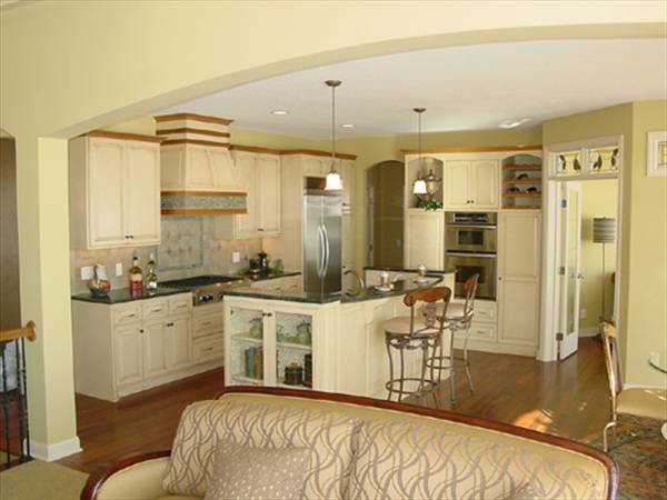 The kitchen is equipped with granite countertops, stainless steel appliances, white cabinetry, and a breakfast island.