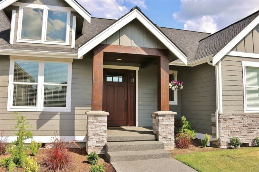 Home entry with a wooden front door guarded by tapered columns.
