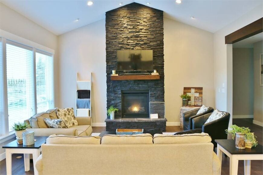 A cathedral ceiling fitted with recessed lights tops the living room.