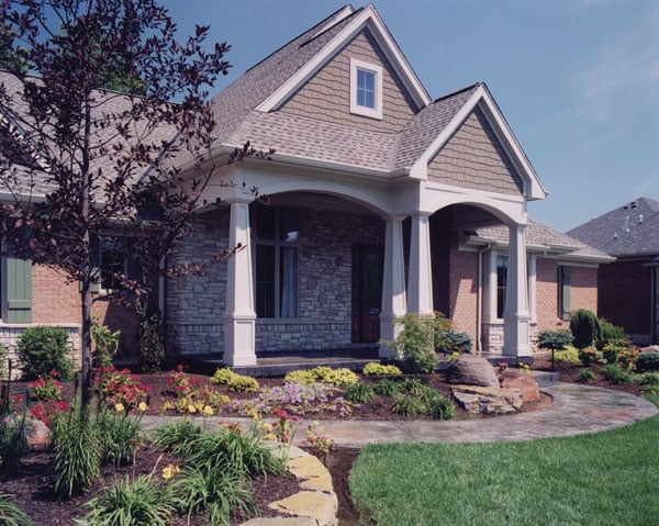 Home entry with a curved walkway and a covered porch lined with tapered columns.