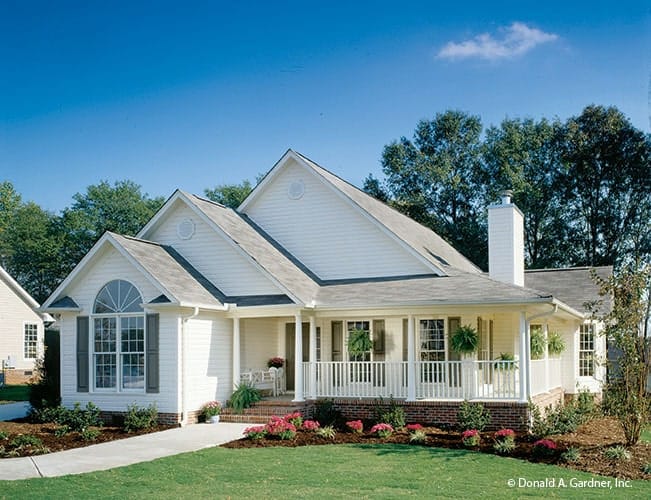 Front exterior view showing the gable rooflines, arched window, brick bases, and a wrap-around porch.