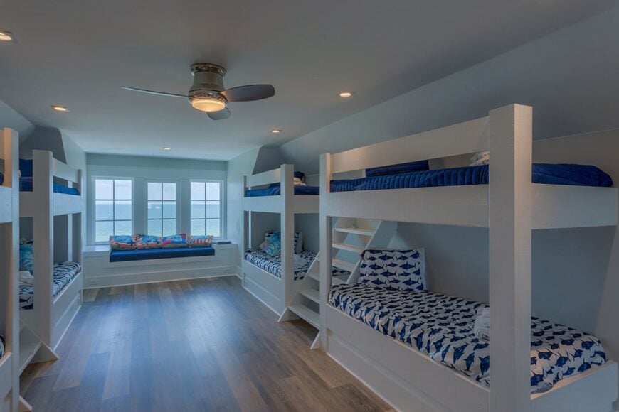 This bedroom is filled with custom bunk beds and a window seat.
