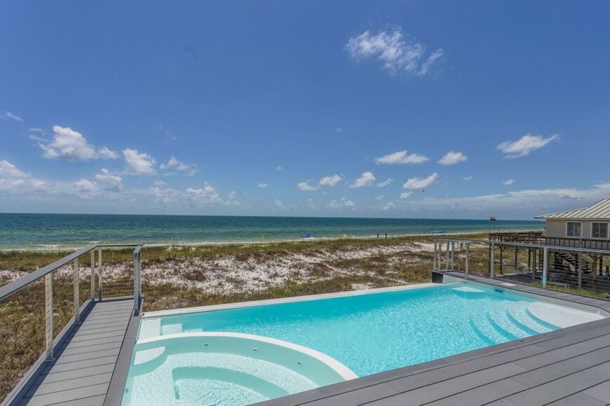 Pool deck featuring an infinity pool overlooking the beach.